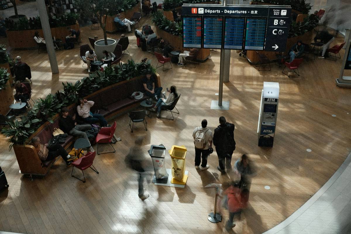 Traveler reviewing delayed flight coverage plan details on smartphone at airport gate